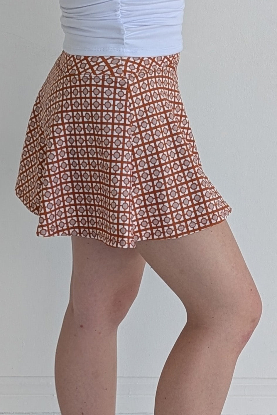 Full bodied burnt orange miniskirt with geometric print and built in shorts and pockets; great for gameday or hanging out with friends.