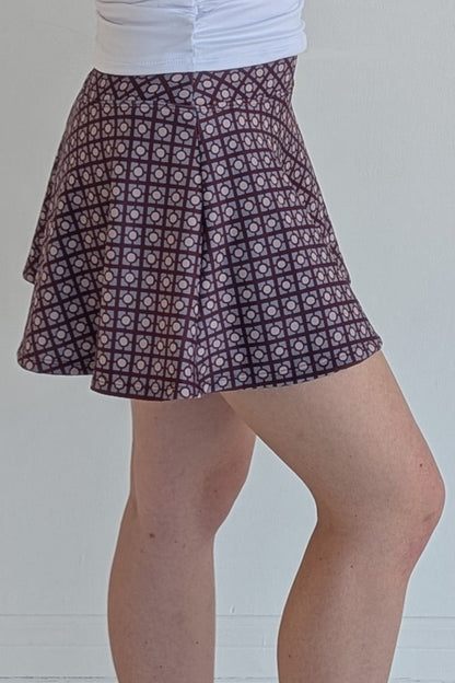 Full bodied maroon miniskirt with geometric print and built in shorts and pockets; great for gameday or hanging out with friends.