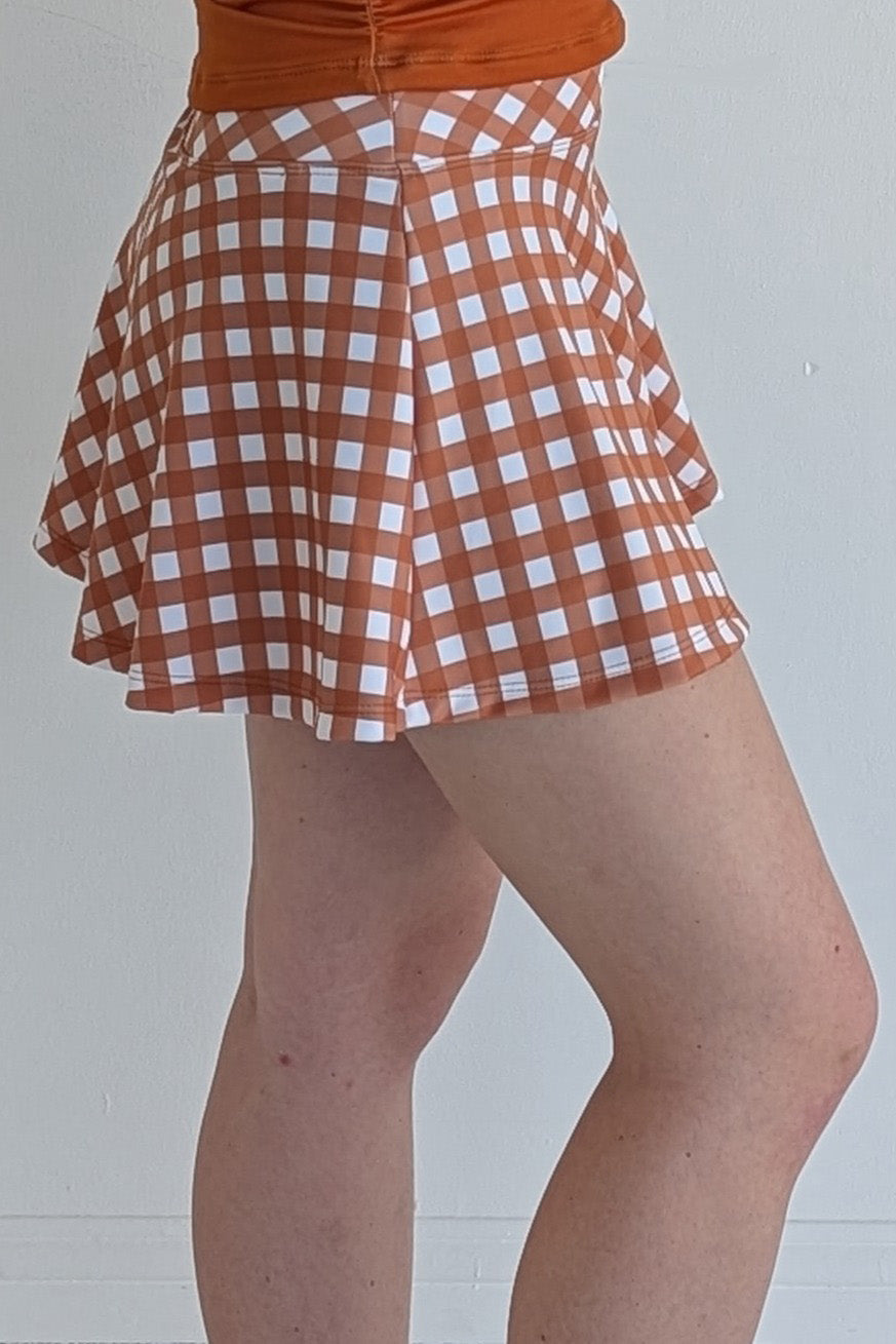 Full bodied burnt orange gingham miniskirt with  built in shorts and pockets; great for gameday or hanging out with friends.