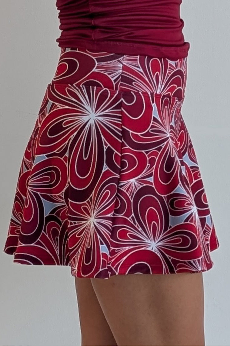 Full bodied crimson miniskirt with 70's inspired flower print and built in shorts and pockets; great for gameday or hanging out with friends.