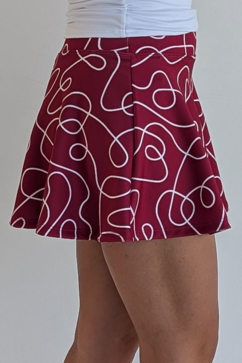 Full bodied crimson miniskirt with scribbles print and built in shorts and pockets; great for gameday or hanging out with friends.