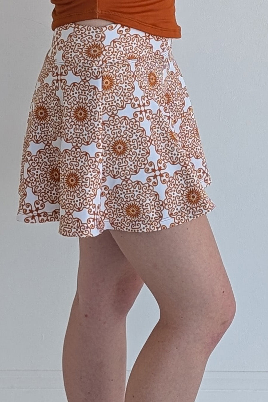Full bodied burnt orange miniskirt with scroll print and built in shorts and pockets; great for gameday or hanging out with friends.